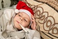 The boy in the Santa hat is sick. Measures the temperature in bed. Illness during the New Years