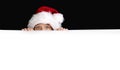 Boy in Santa`s hat surprised and holding white blank billboard for greetings. Royalty Free Stock Photo