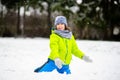 The boy of school age plays snowballs in the winter park.