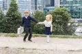 A boy in a school uniform with a small schoolbag pulls a beautiful blonde girl by the hand Royalty Free Stock Photo