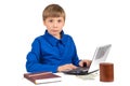 Boy schoolboy in a blue T-shirt preparing for school, studying business, finance: in front of him is a laptop, notebook, pencil Royalty Free Stock Photo