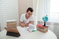 A boy schoolboy does his homework. Textbooks and notebooks on the table Royalty Free Stock Photo