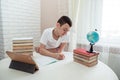 A boy schoolboy does his homework. Textbooks and notebooks on the table Royalty Free Stock Photo