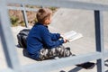 Boy schoolboy sits on the steps and reads a book