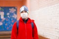 Boy schoolboy walks out of school wearing protective mask