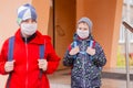 Boy schoolboy walks out of school wearing protective mask