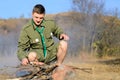 Boy Scout Cooking Sausages on Stick over Campfire Royalty Free Stock Photo