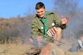 Boy Scout Cooking Sausages on Stick over Campfire Royalty Free Stock Photo