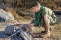 Boy Scout Cooking Sausages on Sticks over Campfire Royalty Free Stock Photo