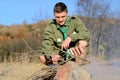 Boy Scout Cooking Sausages on Sticks over Campfire