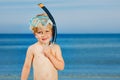 Boy with scuba mask fins stand on a beach ready to dive in sea Royalty Free Stock Photo