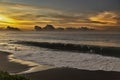 A boy by the sea. A large wave rolls onto a sandy beach. Colorful sunset in Tahiti Royalty Free Stock Photo