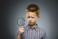 Boy See Through Magnifying Glass, Kid Eye Looking with Magnifier Lens over Gray Royalty Free Stock Photo