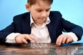 The boy selects money coins up to a certain amount and puts them in his hand