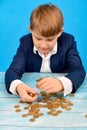 The boy selects money coins up to a certain amount and puts them in his hand