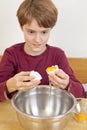 Boy separating egg white from egg yolk Royalty Free Stock Photo