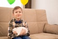 A boy in a shirt and bow tie holds a white rabbit in his arms, smiles and looks at the camera. Easter Royalty Free Stock Photo