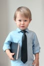 A boy in a shirt and tie with a book in his hands, a smart child