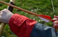 boy shooting arrows targets straw archery archer shooting wooden arrows wings feathers white red blue black jacket cap spring Royalty Free Stock Photo