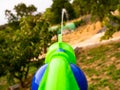 Boy shooting water dispersion with water gun in first person Royalty Free Stock Photo