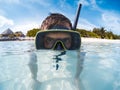 Young man with scuba mask in clear blue water looking to the camera