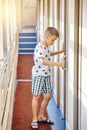 Blond boy opens door into train compartment entering coupe Royalty Free Stock Photo