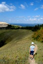 A boy in shorts and a T-shirt goes down the path against the backdrop of a verdant valley and the Volga River. Royalty Free Stock Photo