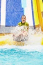 Boy shouts while slides down water-slide Royalty Free Stock Photo