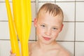 Boy in shower holding paddles from boat