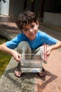 Boy showing off his little container of fish Royalty Free Stock Photo