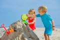 Boy and sister girl play with sand pour water from bucket Royalty Free Stock Photo