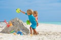 Boy and sister girl play with sand pour water from bucket Royalty Free Stock Photo