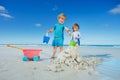 Boy and sister girl play with sand, water at the ocean beach