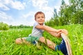 Boy sit on a grass and does gymnastics Royalty Free Stock Photo