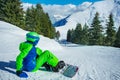 Boy sit on the ski track with snowboard attached look downhill Royalty Free Stock Photo