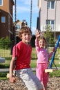 Boy sit on swing and girl waves her hand Royalty Free Stock Photo