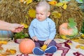 The boy sits on a blanket next to a pumpkin and cries. The boy is sad and unhappy. Autumn season Royalty Free Stock Photo