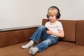 Boy sits on couch and looks to smartphone. Problems of modern life children