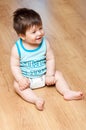 Boy sits on hardwood floor Royalty Free Stock Photo