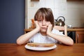 Boy sits at kitchen table and doesn't want to eat Royalty Free Stock Photo