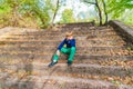 A boy sits on the old steps in the park, wide angle photo bottom view