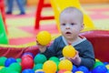 The boy sits in a pile of balls in a dry pool and plays Royalty Free Stock Photo