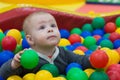 The boy sits in a pile of balls in a dry pool and plays Royalty Free Stock Photo