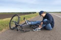 Boy sits in a road after falling from a bike, calms the pain in her knee