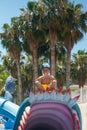 A boy sits on a toothy shark in a water park in the Buddha pose. Royalty Free Stock Photo