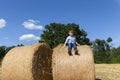 boy sits on top of a golden straw stack