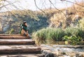 Boy sits on wooden bridge over the mountain lake