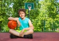 Boy sitting alone with elbow on the ball