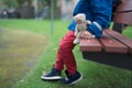 Boy sitting alone in a park with hie teddy bear Royalty Free Stock Photo