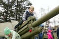 The boy is sitting on the artillery gun, which stand near the museum of the Victory Memorial during the celebration of Victory Day